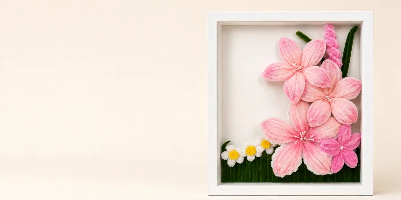 A printed LEAP card standing beside a wrapped bouquet of handmade blooms